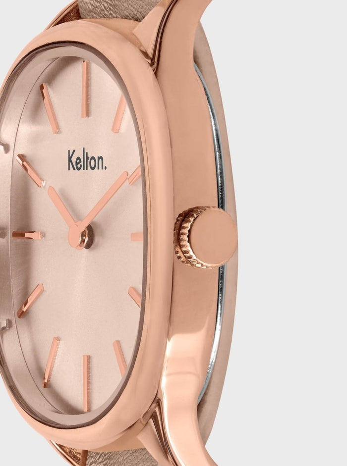Montre or rose, cadran crème, index et aiguilles orange, vue de côté.