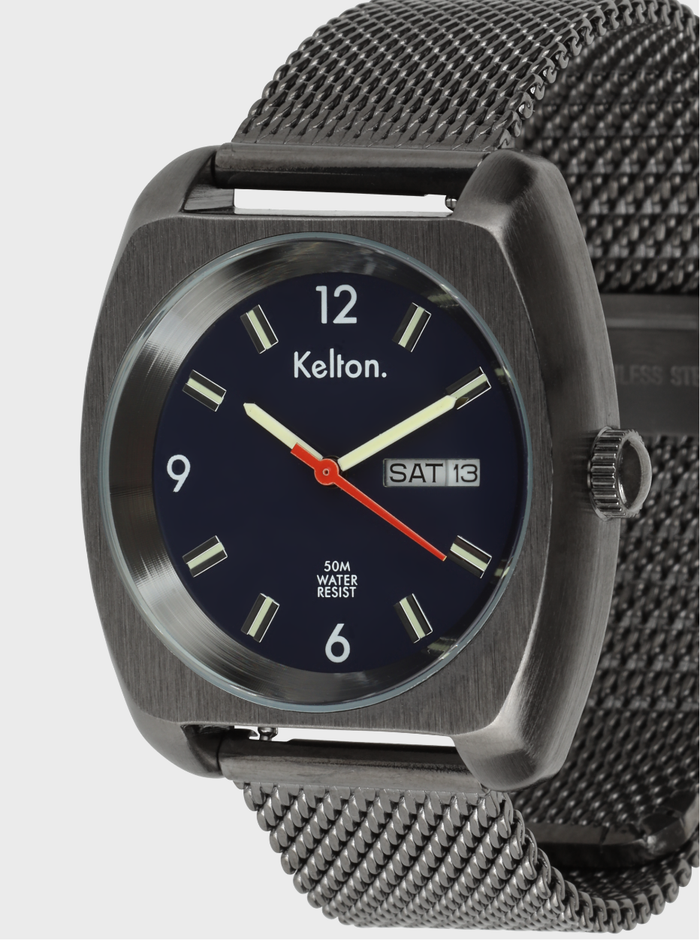 Gros plan de montre à cadran bleu marine et bracelet maille métallique sombre