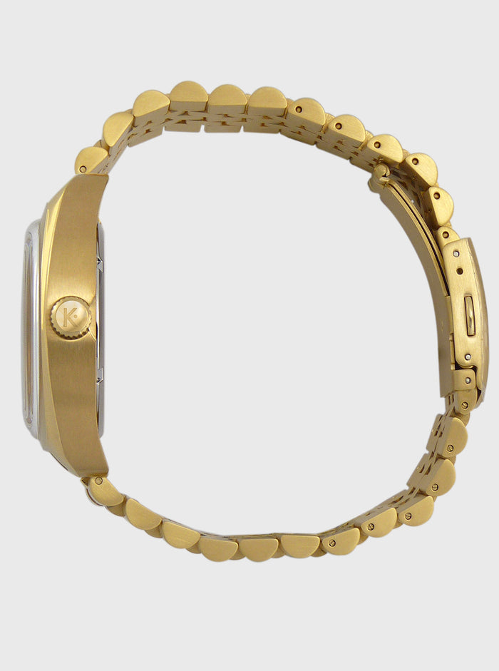 Montre à bracelet acier doré, vue arrière du boîtier et maillons circulaires.