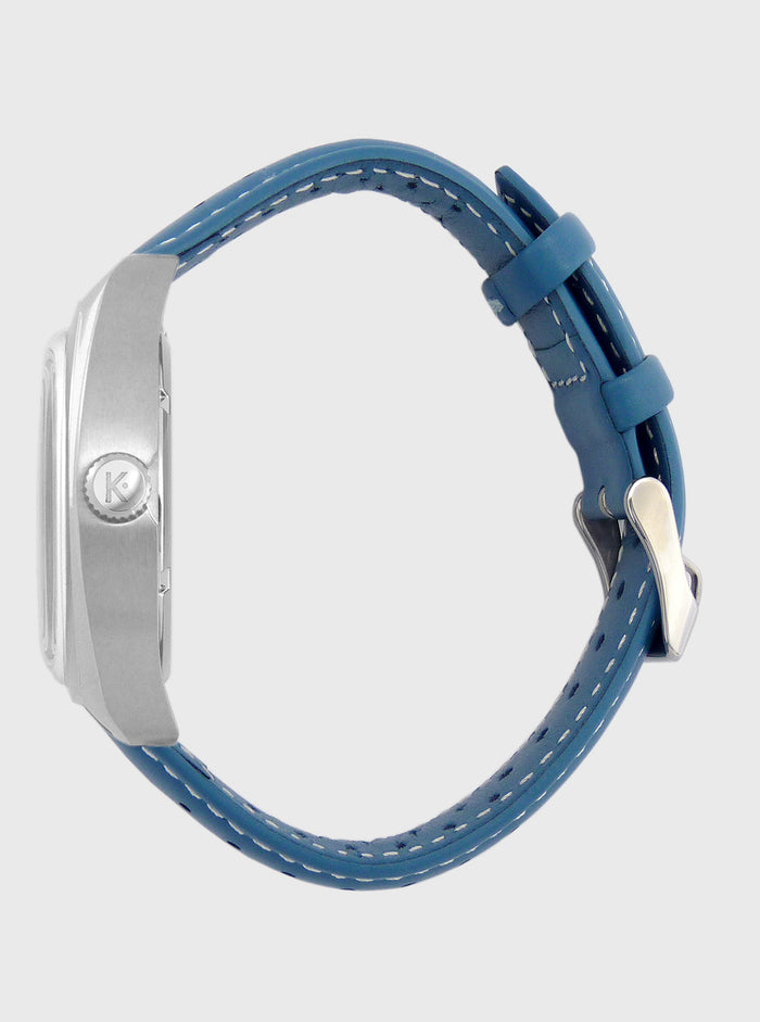 Montre Kelton vue latérale, boîtier argenté et boucle du bracelet cuir bleu.